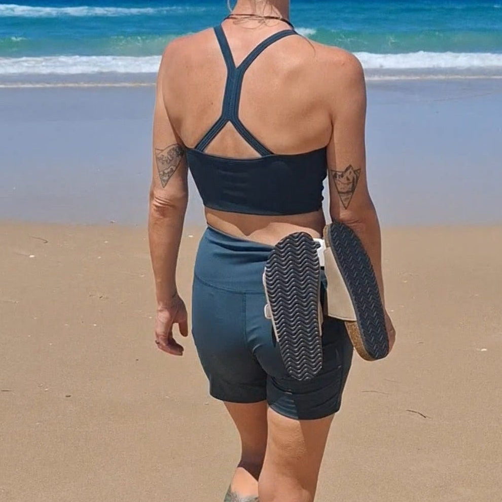 The Sandal Handle™ hands-free sandal carrier clipped to a pair of sandals